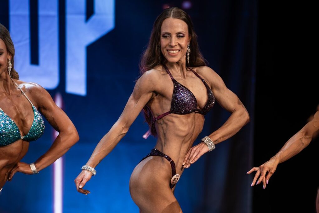 WNBF / SNBF Bikini Athletin Jennifer Stefani nimmt auf der Bühne eine klassische Bikini Pose ein.