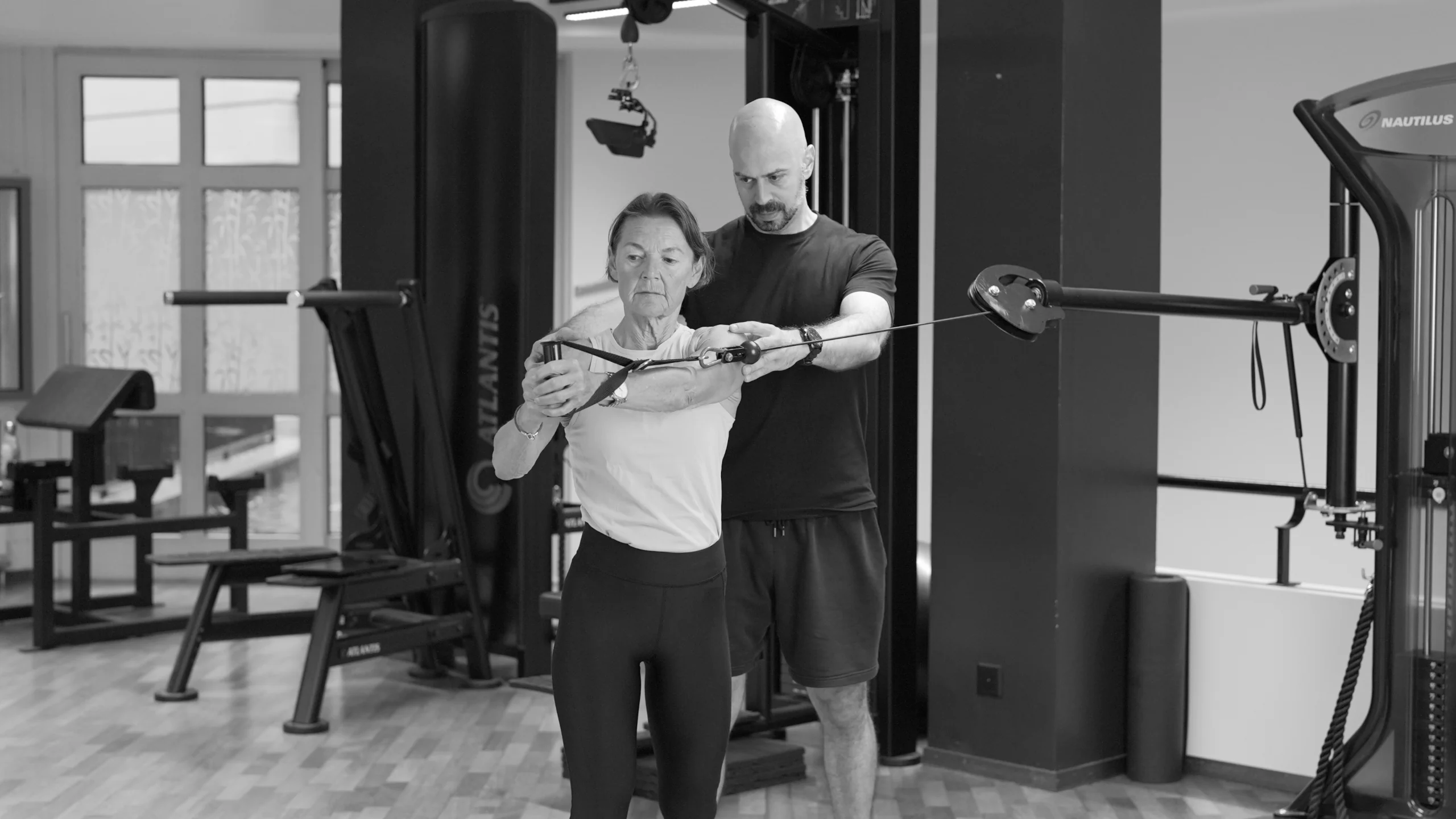 frau-rumpfrotation-mit-coach-semper-fi-body-concept-personal-trainer-baden Eine Frau führt am Kabelzug eine Rumpfrotation aus. Der Coach korrigiert ihre Schultern.